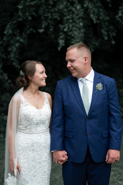 Men wear blue suit jacket, women wear white wedding dress
